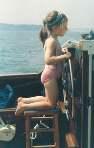 Vicky as a child steering a boat
